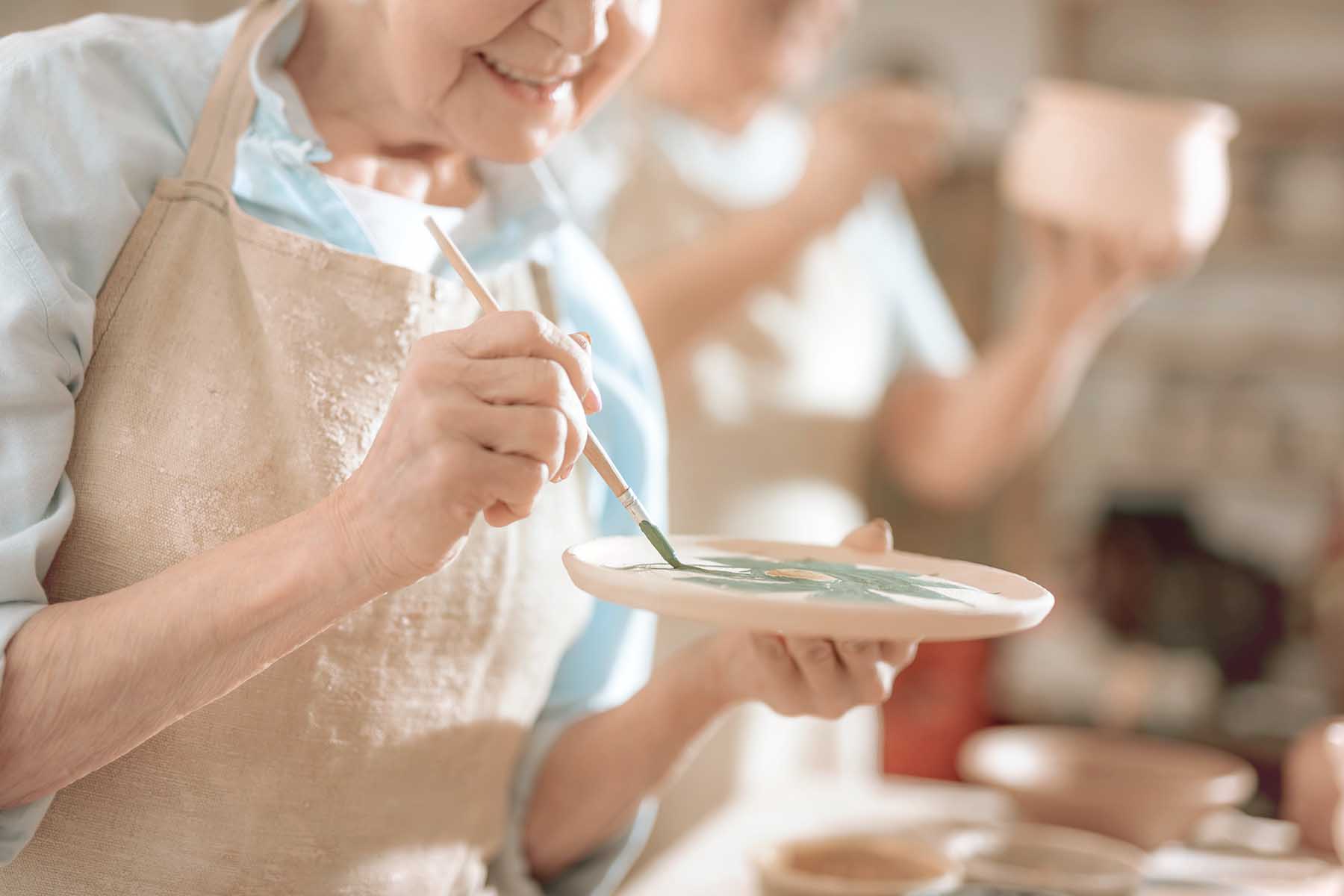 Close up of earthenware in potter's hands. Artist making ornament on ceramic product.